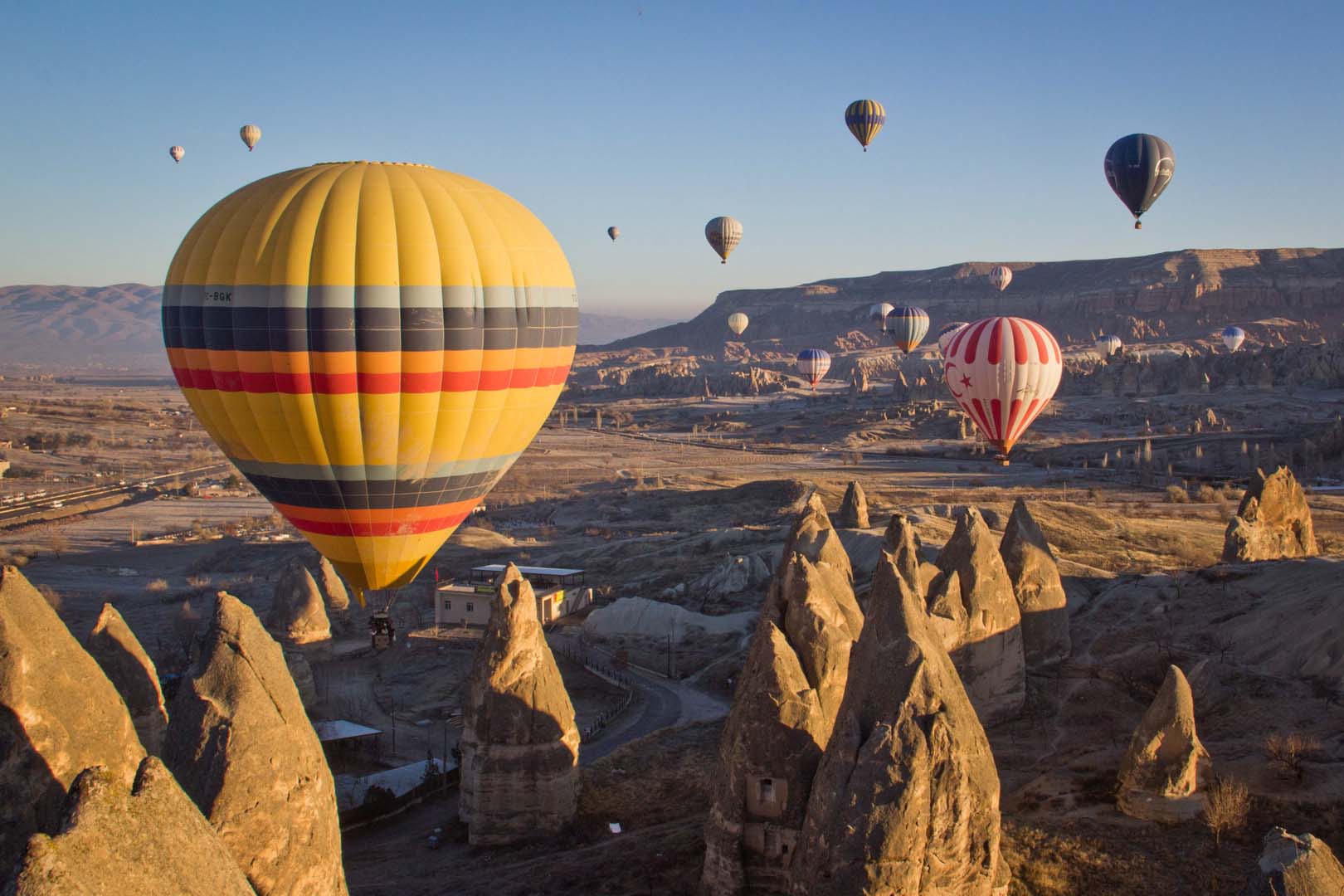 Balloons flying above the chimenys of Cappadocia